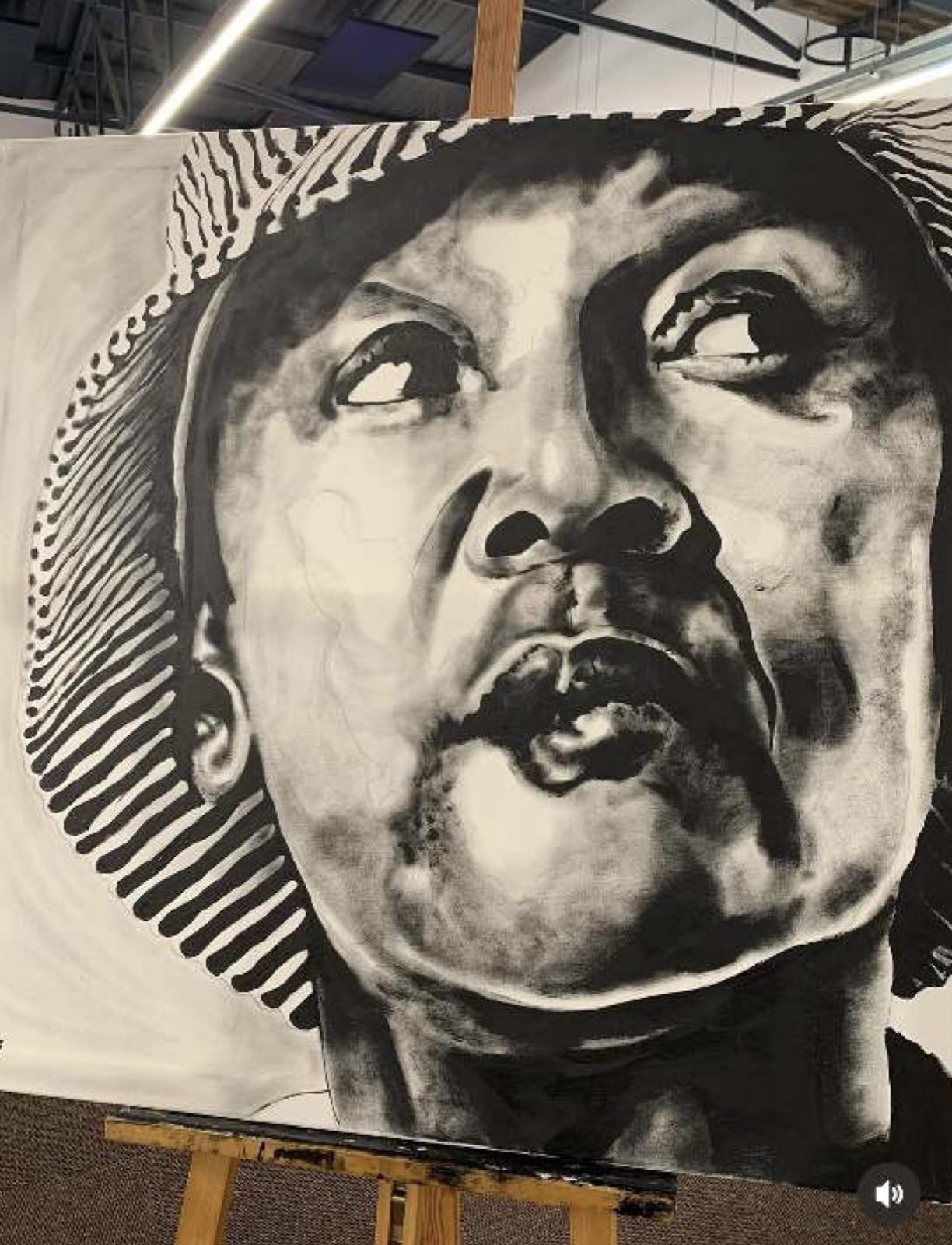 Monochrome portrait of a woman in a striped hat gazing upward